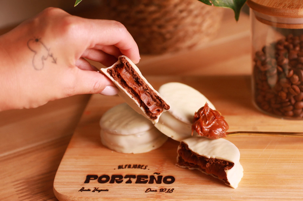 Alfajor Porteño de chocolate branco cortado, com o doce de leite em destaque